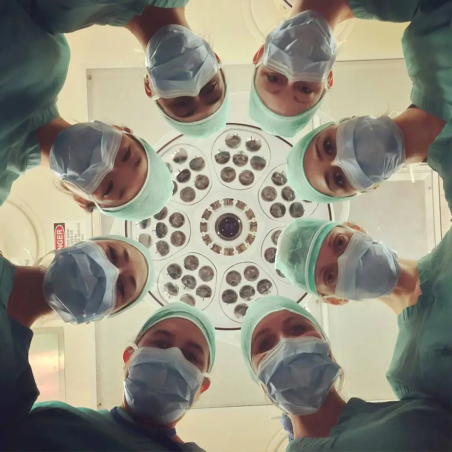 Surgical team around the theatre light — the clinicians ProLocum matches to hospital shifts